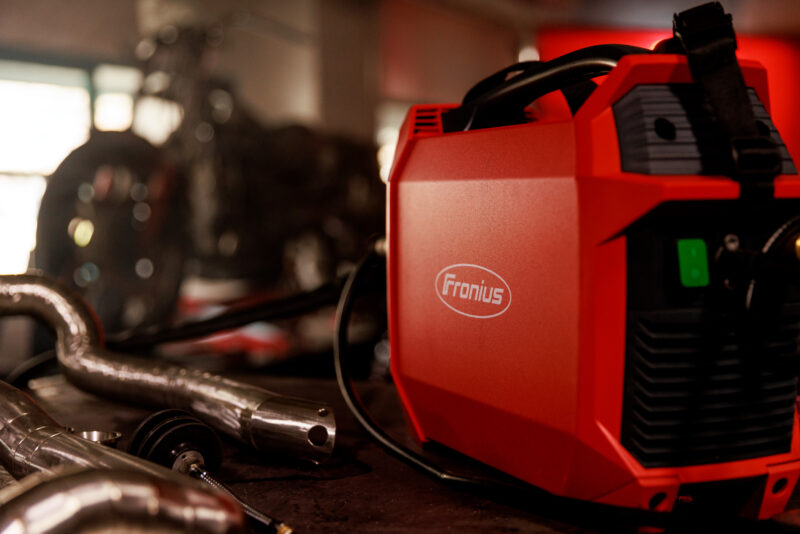 Side profil view of the Fronius Artis: Portable Lightweight TIG Welder next to welding pipe and equipment